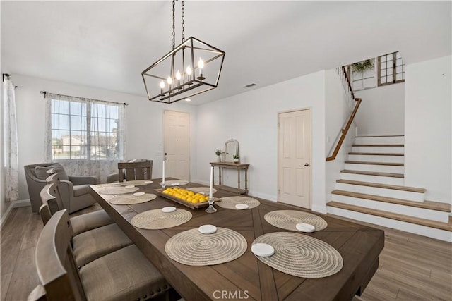 28867 Glencoe Ln, Menifee, CA 92584 - dining area with wood finished floors, baseboards, stairway, and a chandelier