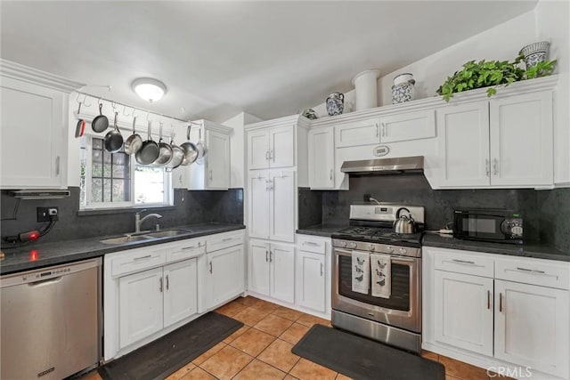 10847 Monogram Ave, Granada Hills, CA 91344 - kitchen with appliances with stainless steel finishes, a sink, under cabinet range hood, and dark countertops