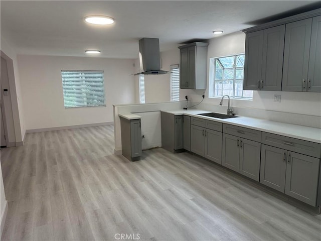 4300 Bancroft Dr, La Mesa, CA 91941 - kitchen featuring gray cabinets, wall chimney range hood, a sink, a peninsula, and light wood-type flooring