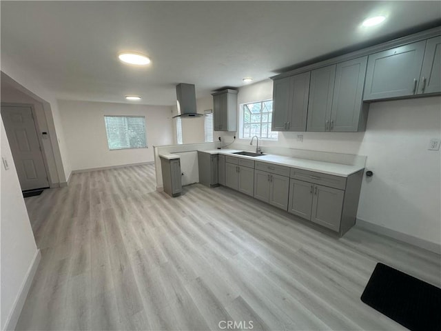 4300 Bancroft Dr, La Mesa, CA 91941 - kitchen featuring gray cabinetry, wall chimney exhaust hood, a sink, baseboards, and light wood-style flooring
