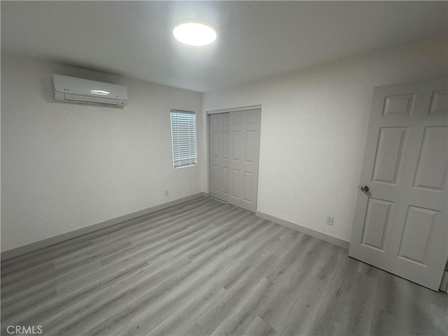 4300 Bancroft Dr, La Mesa, CA 91941 - unfurnished bedroom with a wall mounted AC, light wood-style floors, a closet, and baseboards