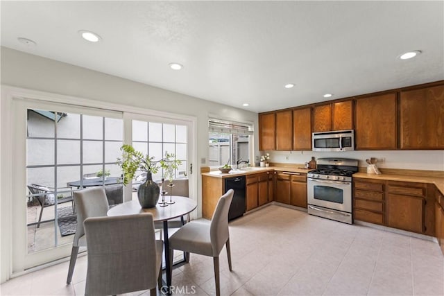 22972 Caminito Linda, Laguna Hills, CA 92653 - kitchen featuring appliances with stainless steel finishes, brown cabinetry, light countertops, recessed lighting, and light tile patterned floors