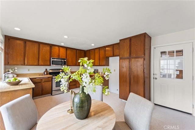 22972 Caminito Linda, Laguna Hills, CA 92653 - kitchen with stainless steel appliances, a sink, light countertops, recessed lighting, and brown cabinets