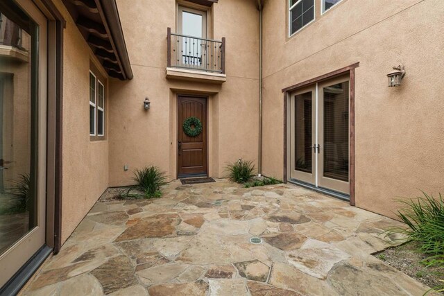 6851 Helenite Pl, Carlsbad, CA 92009 - property entrance featuring french doors, a balcony, a patio, and stucco siding