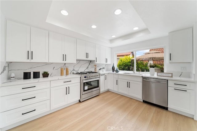 16247 Elza Dr, Hacienda Heights, CA 91745 - kitchen with appliances with stainless steel finishes, a raised ceiling, a sink, light wood-style flooring, and decorative backsplash