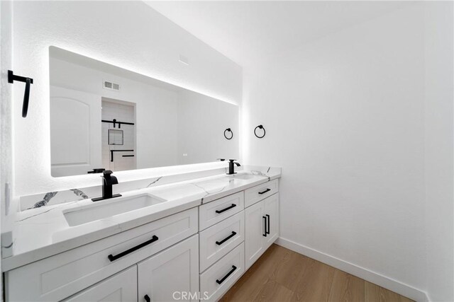 16247 Elza Dr, Hacienda Heights, CA 91745 - full bathroom with wood finished floors, double vanity, and baseboards