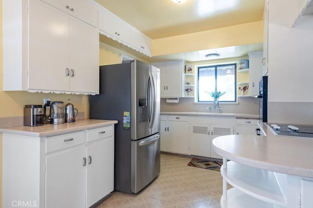 1131 S Vicentia Ave, Corona, CA 92882 - kitchen featuring open shelves, stainless steel fridge, black electric stovetop, and white cabinetry