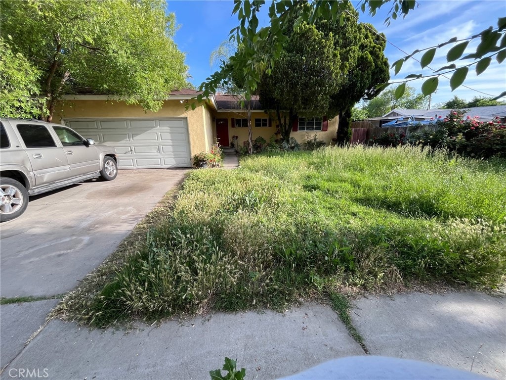 1111 E 27th St, San Bernardino, CA 92404 - view of front of property with stucco siding, a garage, and driveway