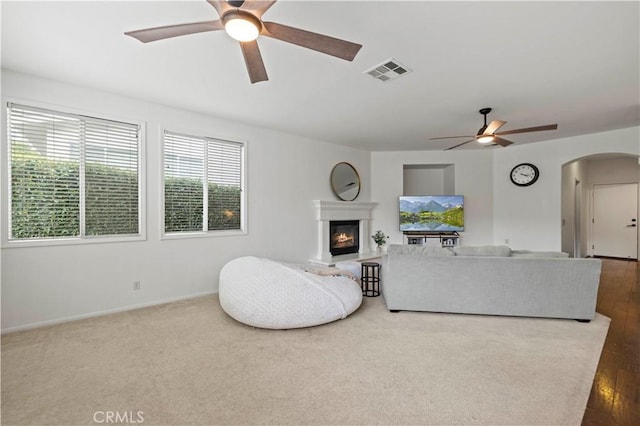 27625 Mariposa Ln, Castaic, CA 91384 - living area featuring a ceiling fan, arched walkways, a glass covered fireplace, and baseboards