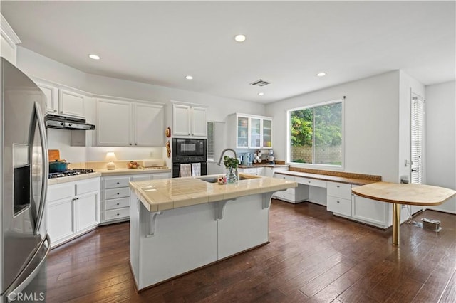 27625 Mariposa Ln, Castaic, CA 91384 - kitchen with a sink, black appliances, white cabinets, a kitchen breakfast bar, and recessed lighting