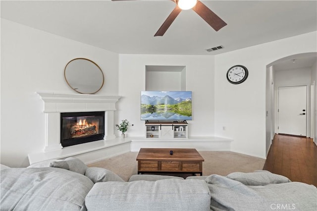 27625 Mariposa Ln, Castaic, CA 91384 - carpeted living area with arched walkways, ceiling fan, and a glass covered fireplace