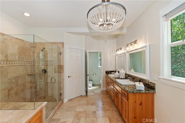 942 Lucerne Ln, Lake Arrowhead, CA 92352 - bathroom featuring double vanity, a stall shower, toilet, a chandelier, and baseboards