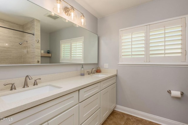 1091 Bradford Ave, Camarillo, CA 93010 - bathroom featuring double vanity, a tile shower, and baseboards