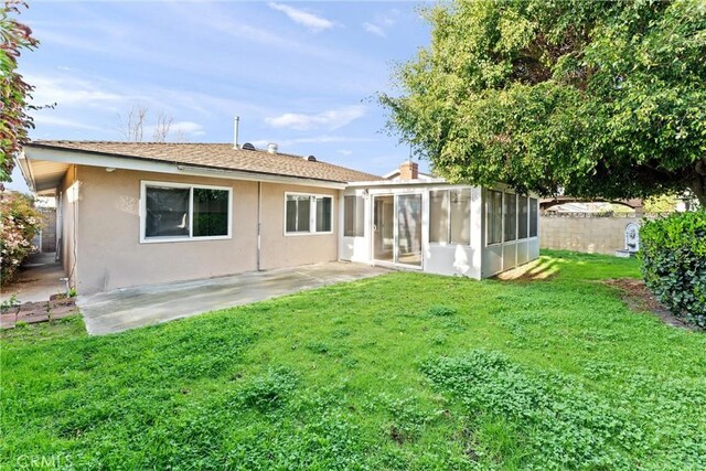 8065 E Ring St, Long Beach, CA 90808 - rear view of property with stucco siding, a sunroom, a yard, and a patio