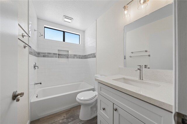 2712 Boundary Ln, Riverside, CA 92503 - full bathroom featuring wood finished floors, vanity, toilet, a textured ceiling, and tub / shower combination