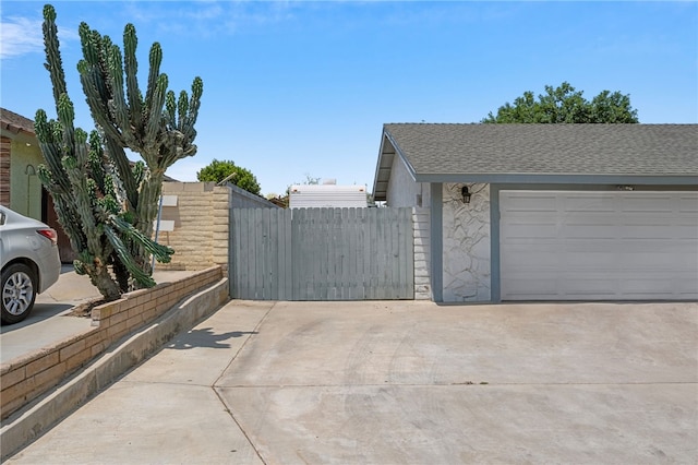 2712 Boundary Ln, Riverside, CA 92503 - view of side of home featuring a gate, stone siding, driveway, and a shingled roof