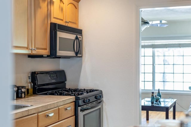 2033 Winnett St, San Diego, CA 92114 - kitchen featuring gas range oven, stainless steel microwave, healthy amount of natural light, and tile countertops
