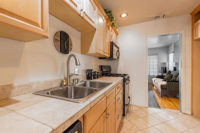 2033 Winnett St, San Diego, CA 92114 - kitchen featuring range with gas cooktop, stainless steel microwave, light countertops, light tile patterned floors, and recessed lighting