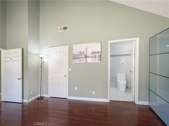 3855 Gilman Rd, El Monte, CA 91732 - unfurnished bedroom with high vaulted ceiling, wood finished floors, and baseboards