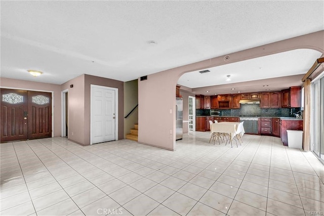 3855 Gilman Rd, El Monte, CA 91732 - unfurnished living room featuring stairs, arched walkways, light tile patterned floors, and a sink