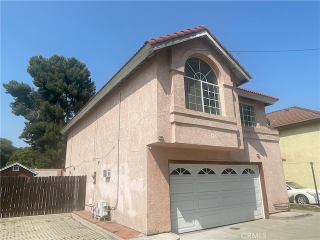 3855 Gilman Rd, El Monte, CA 91732 - view of side of home with stucco siding, a garage, a tile roof, and central AC