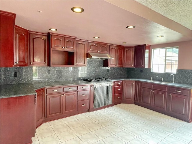 3855 Gilman Rd, El Monte, CA 91732 - kitchen featuring under cabinet range hood, stainless steel gas cooktop, backsplash, recessed lighting, and reddish brown cabinets