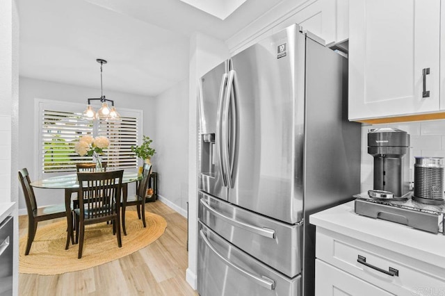 783 Brookstone Rd Unit 104, Chula Vista, CA 91913 - kitchen with stainless steel fridge with ice dispenser, light wood-type flooring, white cabinets, light countertops, and decorative backsplash
