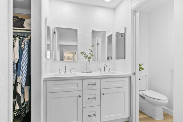 783 Brookstone Rd Unit 104, Chula Vista, CA 91913 - bathroom featuring double vanity, a spacious closet, and wood finished floors