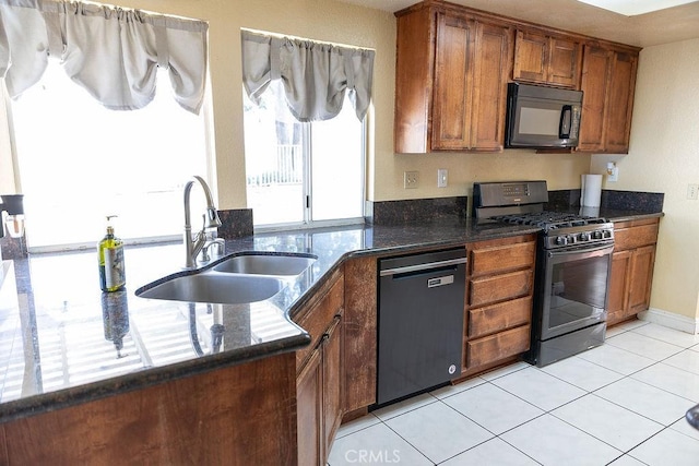 27474 Bolandra Ct, Temecula, CA 92591 - kitchen with black microwave, range with gas cooktop, dishwashing machine, brown cabinetry, and dark stone counters