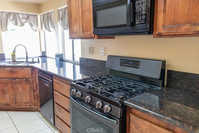 27474 Bolandra Ct, Temecula, CA 92591 - kitchen with range with gas stovetop, black microwave, dishwashing machine, brown cabinetry, and a textured wall