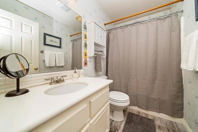 1064 Eliot St, Oceanside, CA 92057 - bathroom featuring vanity, wallpapered walls, wood finished floors, and a shower with shower curtain