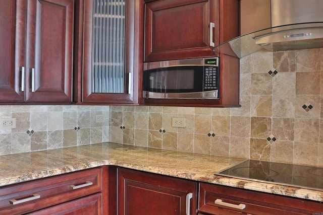 1200 N Harbor Dr Unit 15B, Oceanside, CA 92054 - kitchen with stainless steel microwave, dark brown cabinets, black electric stovetop, wall chimney range hood, and light stone counters