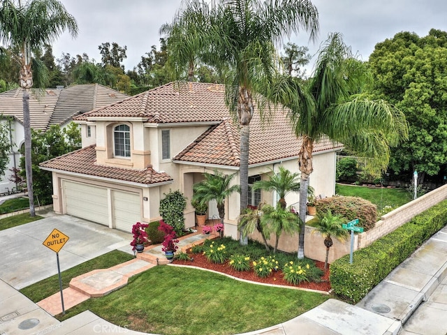28 Covington, Mission Viejo, CA 92692 - mediterranean / spanish house featuring a tile roof, concrete driveway, stucco siding, a front lawn, and a garage