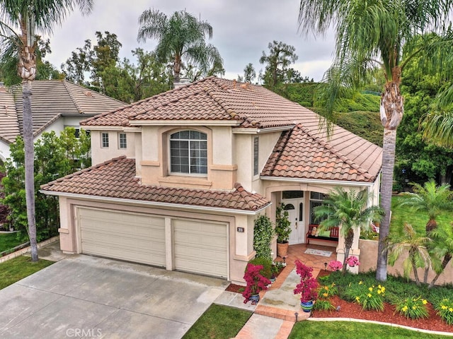 28 Covington, Mission Viejo, CA 92692 - mediterranean / spanish home featuring a tiled roof, concrete driveway, stucco siding, and a garage