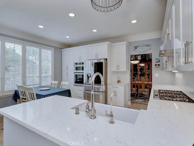 28 Covington, Mission Viejo, CA 92692 - kitchen with appliances with stainless steel finishes, ornamental molding, healthy amount of natural light, light stone countertops, and white cabinets