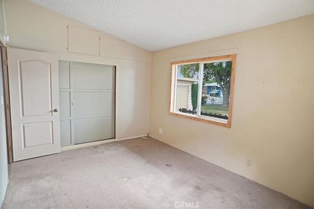44037 Heaton Ave, Lancaster, CA 93534 - unfurnished bedroom with light carpet, a closet, a textured ceiling, and lofted ceiling