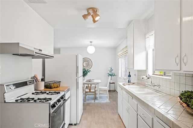 1139 W 149th St, Gardena, CA 90247 - kitchen featuring white gas range oven, a sink, tile countertops, light wood-type flooring, and white cabinetry
