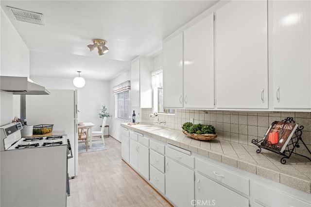 1139 W 149th St, Gardena, CA 90247 - kitchen featuring white gas stove, a sink, tasteful backsplash, and white cabinetry
