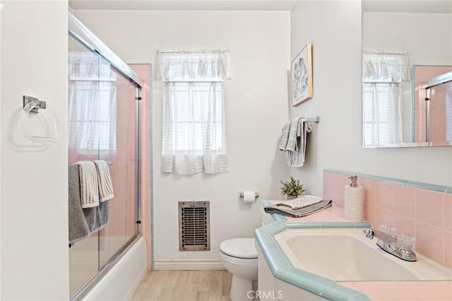 1139 W 149th St, Gardena, CA 90247 - full bath featuring heating unit, toilet, shower / bath combination with glass door, vanity, and wood finished floors