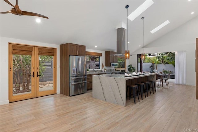 3995 Cypress Del Mar, San Diego, CA 92130 - kitchen with stainless steel fridge with ice dispenser, french doors, light wood-style flooring, a spacious island, and a kitchen breakfast bar