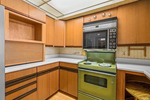 3635 7th Ave Unit 13E, San Diego, CA 92103 - kitchen featuring range with electric stovetop, stainless steel microwave, and light countertops