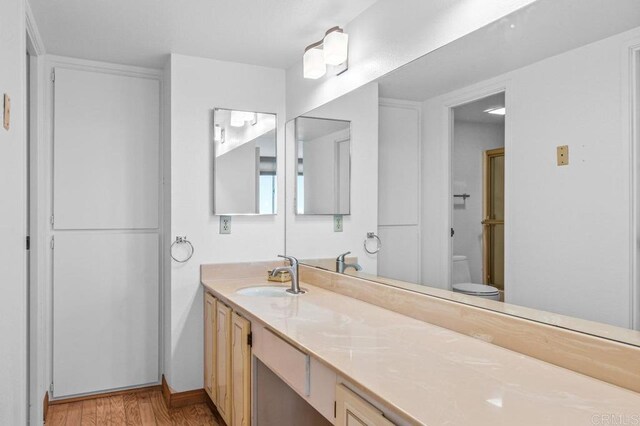 3635 7th Ave Unit 13E, San Diego, CA 92103 - bathroom with wood finished floors, vanity, toilet, and baseboards