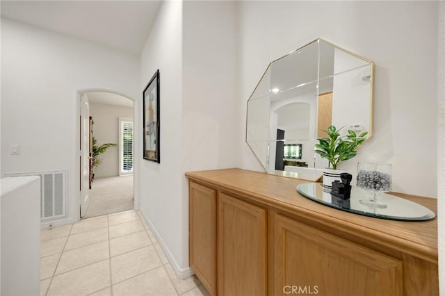 23820 Towish Dr, Corona, CA 92883 - hall featuring arched walkways, light tile patterned floors, light carpet, and baseboards