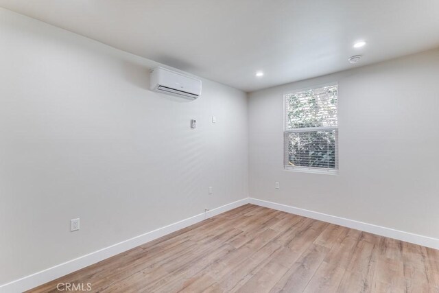 2756 W 15th St, Los Angeles, CA 90006 - empty room with an AC wall unit, light wood-style flooring, baseboards, recessed lighting, and a smoke detector
