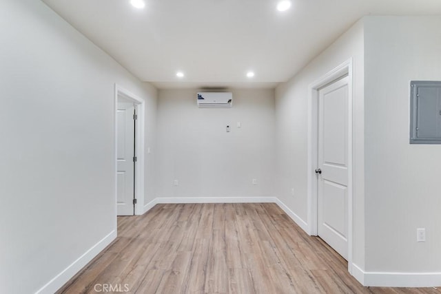 2756 W 15th St, Los Angeles, CA 90006 - empty room with electric panel, a wall mounted AC, recessed lighting, light wood-style floors, and baseboards