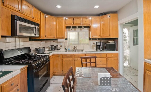 2756 W 15th St, Los Angeles, CA 90006 - kitchen featuring black appliances, a sink, light tile patterned flooring, decorative backsplash, and recessed lighting