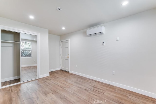 2756 W 15th St, Los Angeles, CA 90006 - unfurnished bedroom featuring a wall mounted AC, light wood-type flooring, baseboards, recessed lighting, and a closet