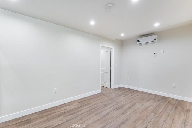 2756 W 15th St, Los Angeles, CA 90006 - unfurnished room with a wall unit AC, baseboards, light wood-style flooring, recessed lighting, and a smoke detector