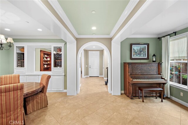 7 Illuminata Ln, Ladera Ranch, CA 92694 - foyer featuring ornamental molding, arched walkways, baseboards, light tile patterned floors, and a chandelier