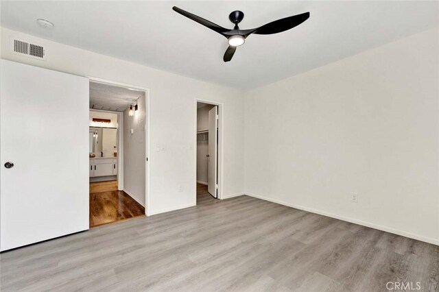 3062 Associated Rd Unit 9, Fullerton, CA 92835 - unfurnished bedroom with wood finished floors, a spacious closet, ensuite bathroom, and baseboards